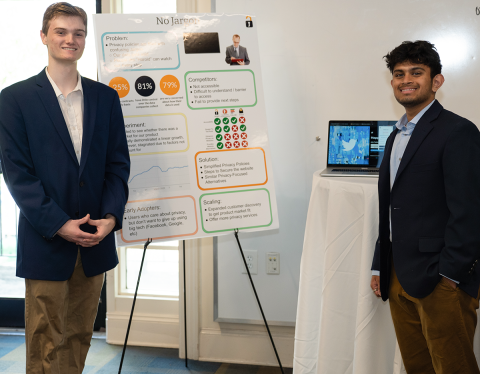 The No Jargon team standing besides their presentation project poster.