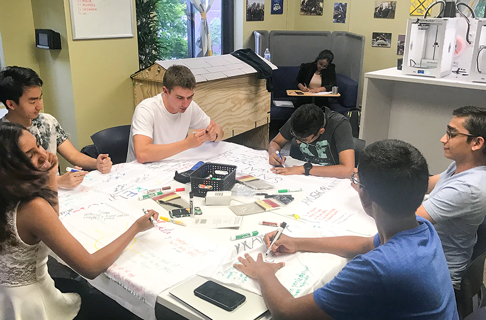 A group of students working on a project at a round table.